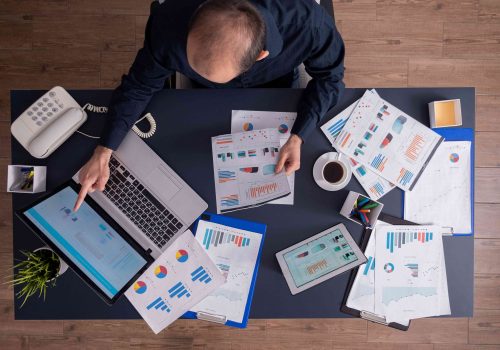 top-view-businessman-pointing-financial-statistics